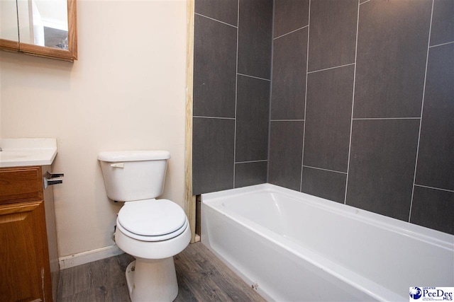 bathroom featuring vanity, wood finished floors, toilet, and baseboards