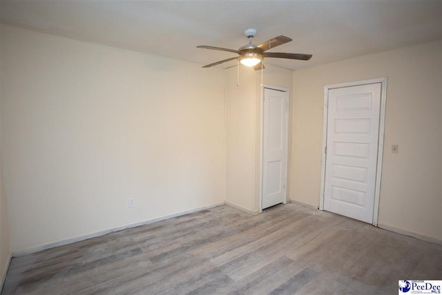 unfurnished bedroom featuring ceiling fan, light wood finished floors, a closet, and baseboards