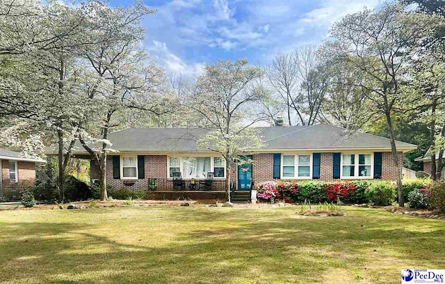 ranch-style home with a front yard and brick siding