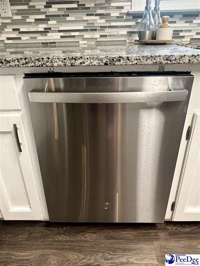 details with dark wood-style flooring, dishwasher, white cabinetry, and decorative backsplash