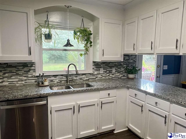 kitchen with stainless steel dishwasher, a sink, and white cabinets