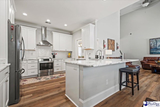 kitchen featuring a sink, freestanding refrigerator, wall chimney exhaust hood, range, and dark wood-style flooring