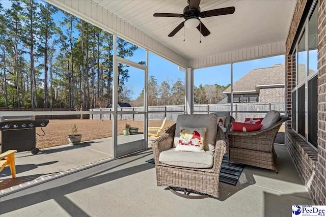 sunroom / solarium featuring a ceiling fan