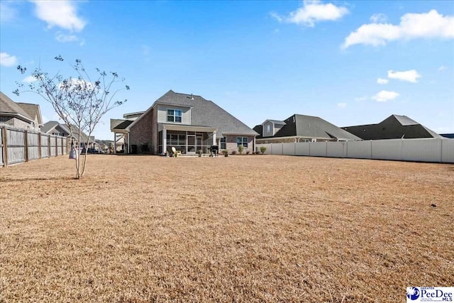 view of yard with a fenced backyard and a sunroom