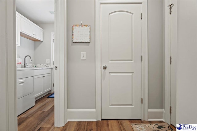 interior space featuring washer / dryer, baseboards, and wood finished floors