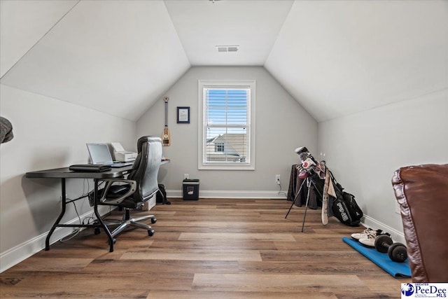 home office featuring vaulted ceiling, visible vents, baseboards, and wood finished floors