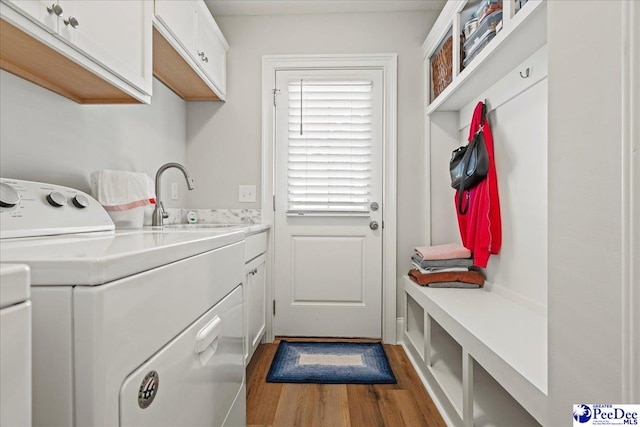 laundry room featuring a sink, cabinet space, separate washer and dryer, and dark wood-style floors