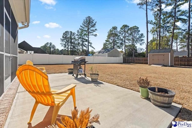 view of patio / terrace with an outbuilding, area for grilling, a fenced backyard, and a storage shed