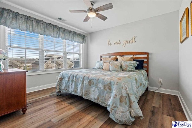 bedroom featuring wood finished floors, visible vents, and baseboards