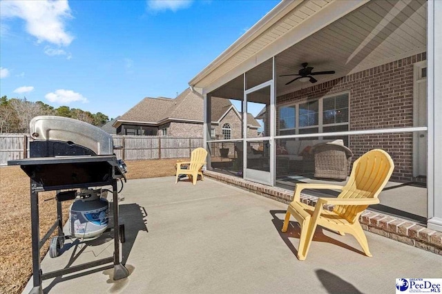 view of patio / terrace featuring a grill, a sunroom, a ceiling fan, and fence