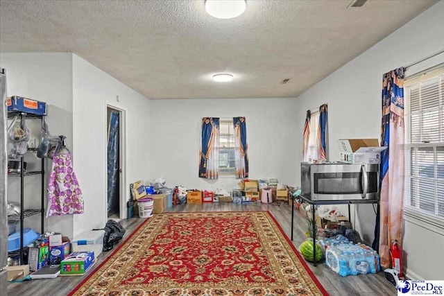 game room featuring hardwood / wood-style floors and a textured ceiling