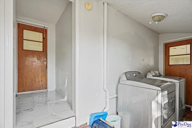 washroom featuring washing machine and dryer and a textured ceiling