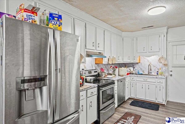 kitchen featuring stainless steel appliances, hardwood / wood-style flooring, sink, and white cabinets