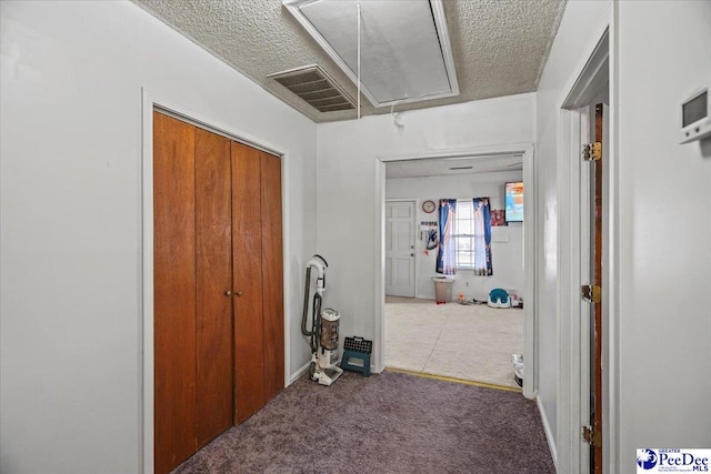 corridor featuring carpet floors and a textured ceiling