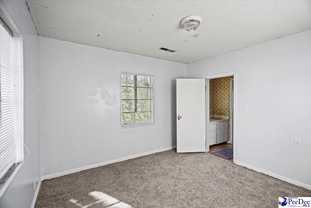 unfurnished bedroom featuring carpet floors and a textured ceiling