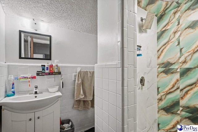 bathroom featuring vanity, tile walls, and a textured ceiling