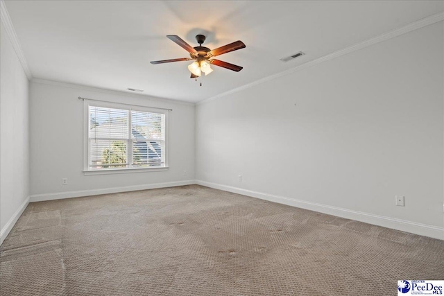 unfurnished room featuring crown molding, carpet, baseboards, visible vents, and ceiling fan