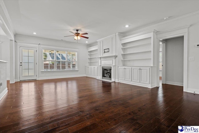 unfurnished living room featuring crown molding, baseboards, a fireplace with raised hearth, ceiling fan, and wood-type flooring
