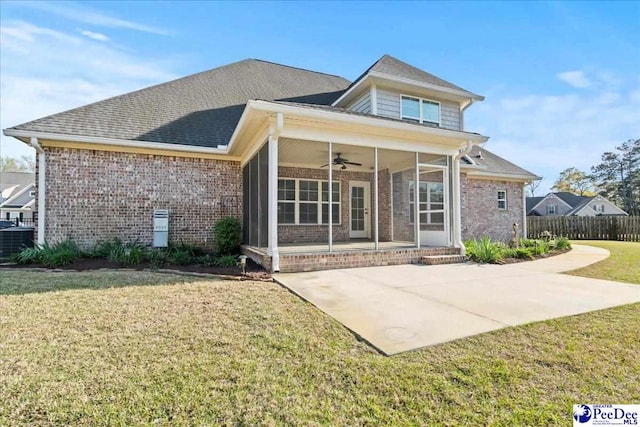 back of property featuring a lawn, a sunroom, a patio, and brick siding