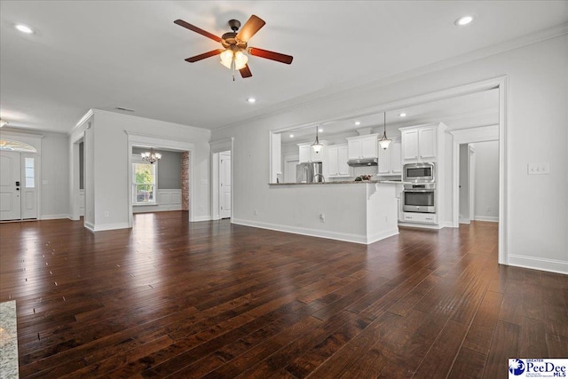 unfurnished living room featuring crown molding, baseboards, recessed lighting, ceiling fan with notable chandelier, and dark wood-style floors