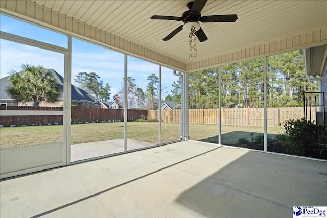 unfurnished sunroom with ceiling fan