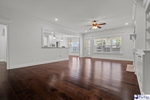 unfurnished living room featuring dark wood finished floors, crown molding, baseboards, and ceiling fan
