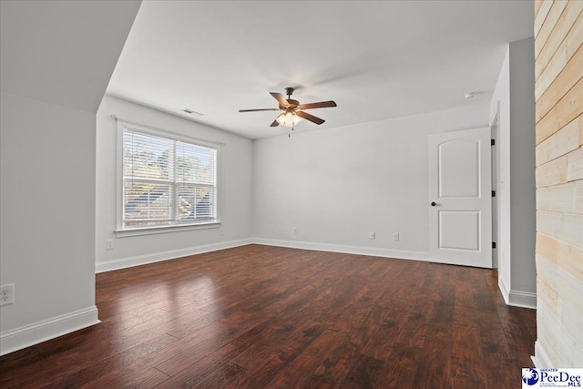 spare room featuring baseboards, wood finished floors, and a ceiling fan