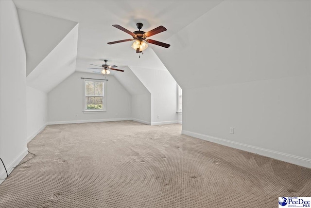 bonus room with a ceiling fan, light carpet, baseboards, and vaulted ceiling