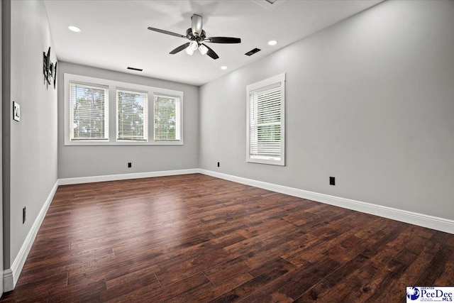 unfurnished room featuring a wealth of natural light, dark hardwood / wood-style floors, and ceiling fan