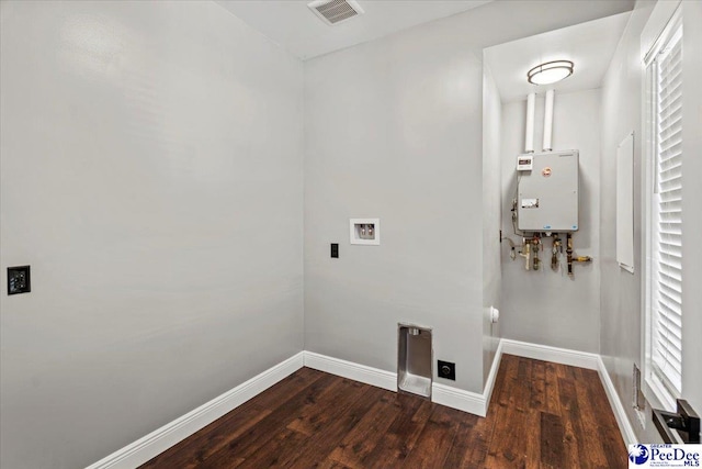 clothes washing area featuring tankless water heater, washer hookup, and dark hardwood / wood-style flooring