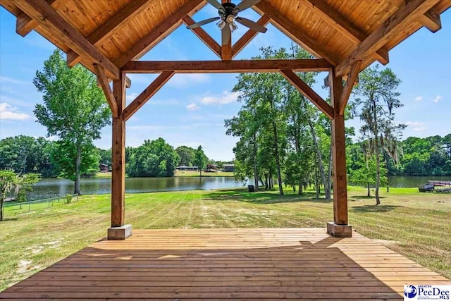 wooden terrace with a gazebo, a water view, a yard, and ceiling fan