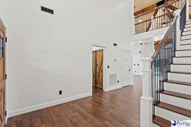 staircase featuring hardwood / wood-style flooring and a high ceiling