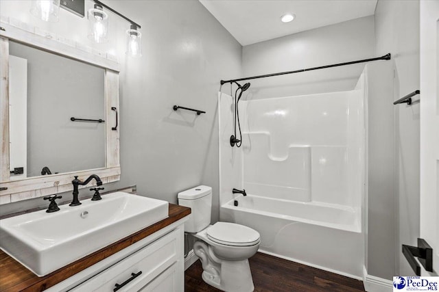 full bathroom featuring shower / bath combination, vanity, hardwood / wood-style flooring, and toilet