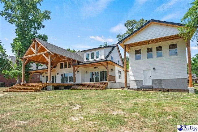 rear view of house with a lawn and ceiling fan