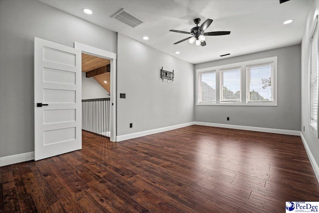 spare room featuring dark wood-type flooring and ceiling fan