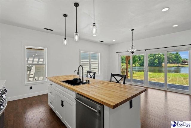 kitchen featuring wood counters, sink, a water view, an island with sink, and white cabinets