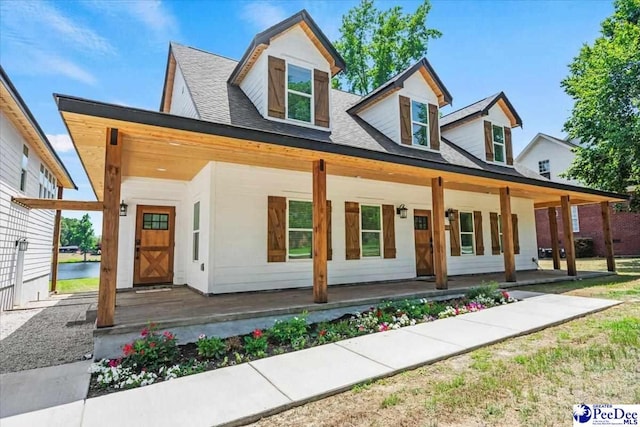 cape cod-style house featuring covered porch