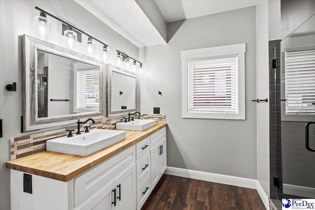 bathroom with a wealth of natural light, hardwood / wood-style floors, walk in shower, and decorative backsplash