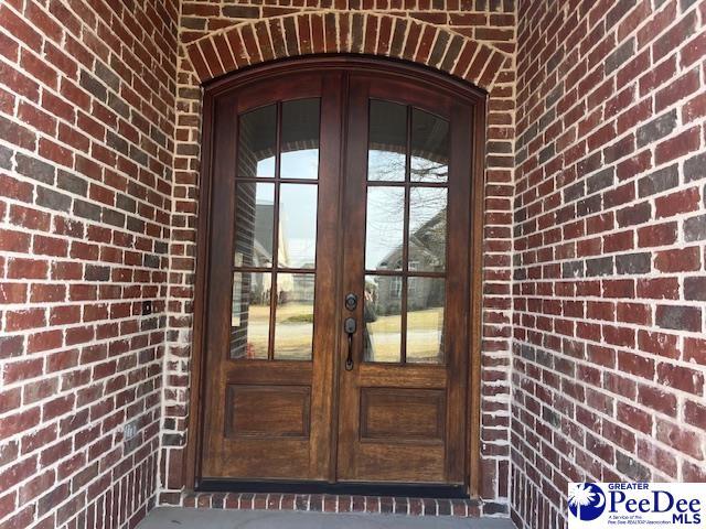 doorway to property with french doors and brick siding