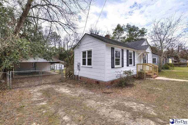 view of home's exterior featuring a shingled roof, fence, a chimney, crawl space, and a gate