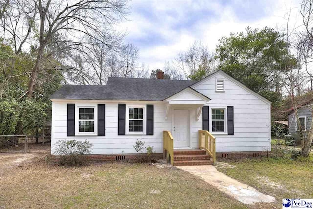 bungalow-style home featuring a shingled roof, fence, a chimney, and crawl space