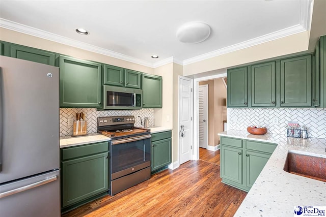 868 Moonshadow Ln, Darlington, SC 29540 - kitchen featuring appliances with stainless steel finishes, green cabinetry, light countertops, decorative backsplash, and ornamental molding