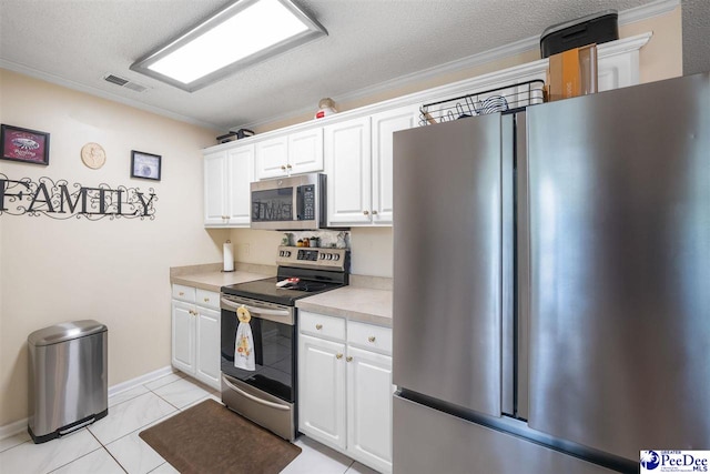 kitchen with white cabinets, light countertops, stainless steel appliances, and visible vents