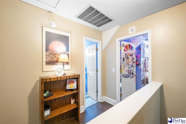 hallway featuring visible vents, baseboards, and dark wood-type flooring