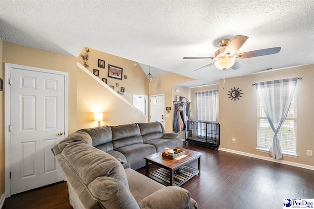 living area with a textured ceiling, baseboards, a ceiling fan, and wood finished floors