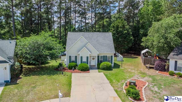 view of front of property with a shingled roof and a front yard