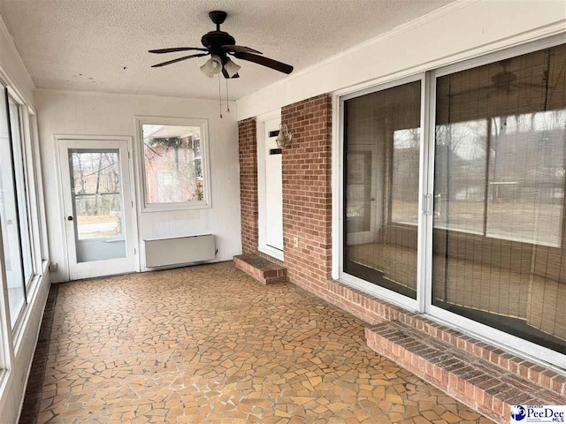 unfurnished sunroom with a ceiling fan