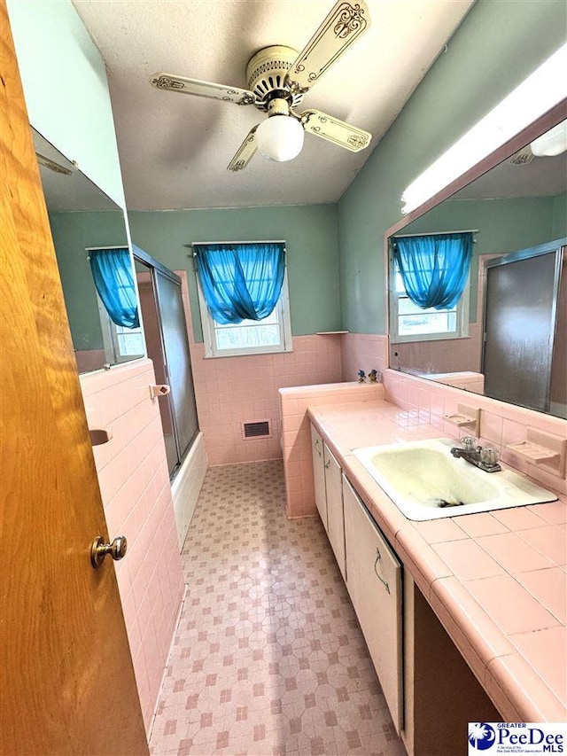 bathroom with a wainscoted wall, tile walls, visible vents, vanity, and tile patterned floors