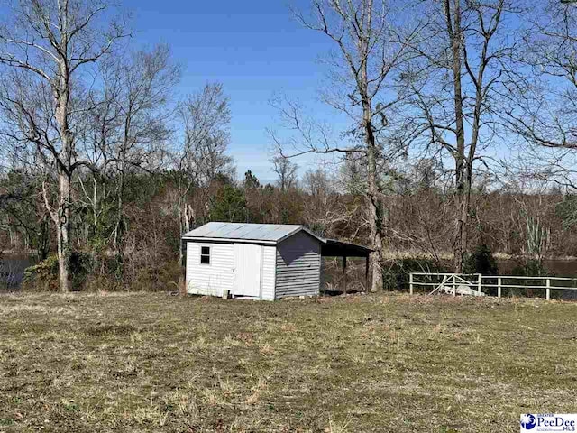 view of yard featuring an outbuilding, fence, and a storage shed