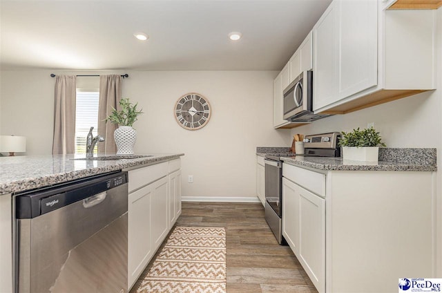 597 Strawberry Field Way, Galivants Ferry, SC 29544 - kitchen featuring stainless steel appliances, a sink, light wood-type flooring, white cabinets, and recessed lighting